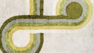Rectangular geometric rug with a white background and yellow and green pattern