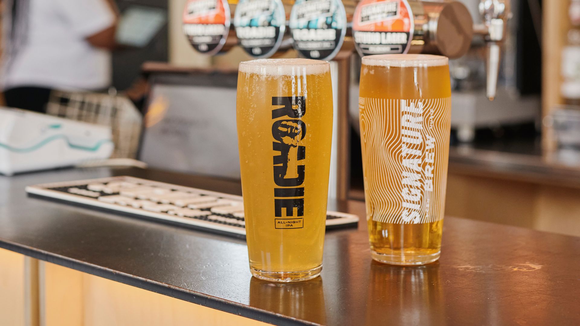 an image of two pint of beer on a counter in a pub 