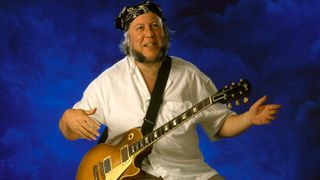 Photo of Peter GREEN; posed, studio, holding the Gibson Les Paul guitar he sold to Gary Moore