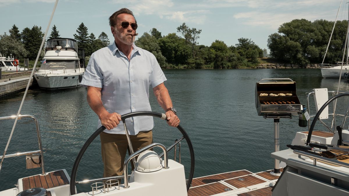 Arnold Schwarzenegger at the helm of a boat with a cigar in his mouth in FUBAR