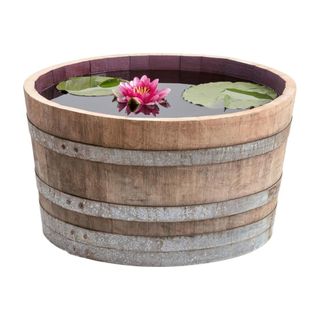 barrel-shaped mini pond filled with water and water lillies and lily pads