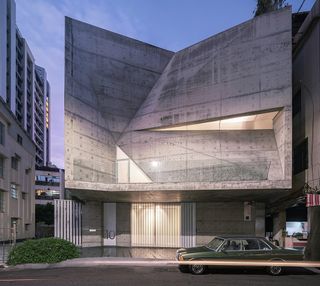 hero nighttime exterior of the concrete facade of star house in taiwan lit from within