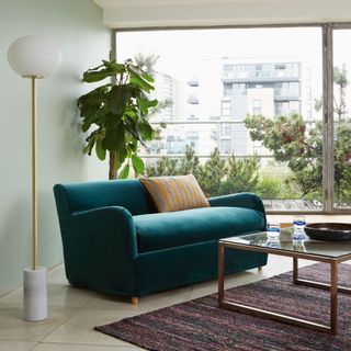living room with white tiled flooring and blue sofa sets with cushions