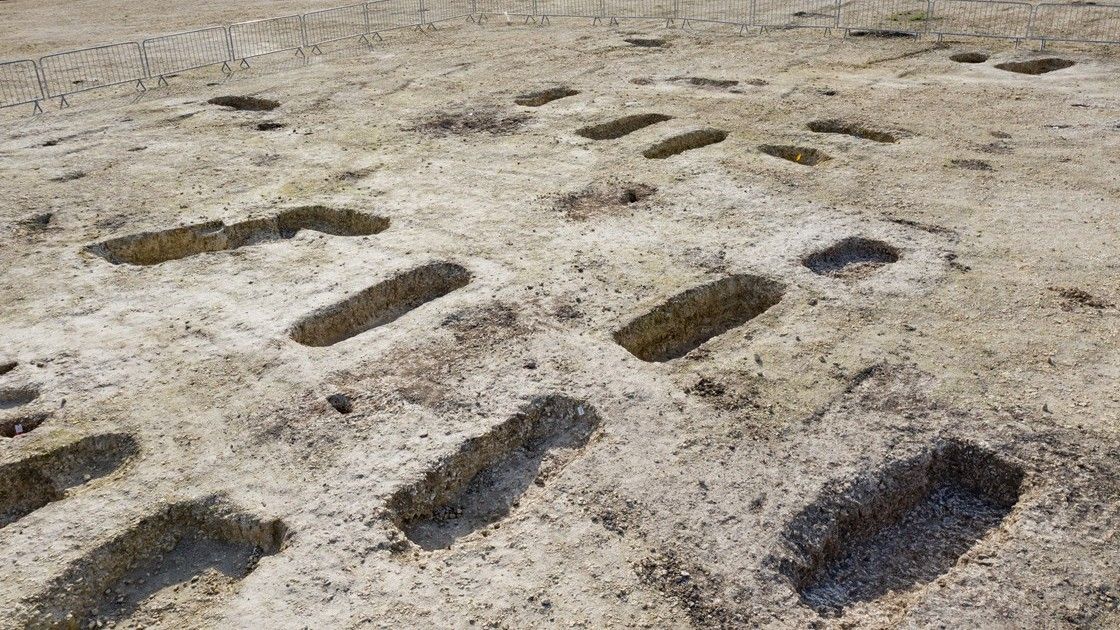 This is a wide over shot of a burial site showing a number of unearthed Anglo-Saxon graves (at least 12 in the picture).