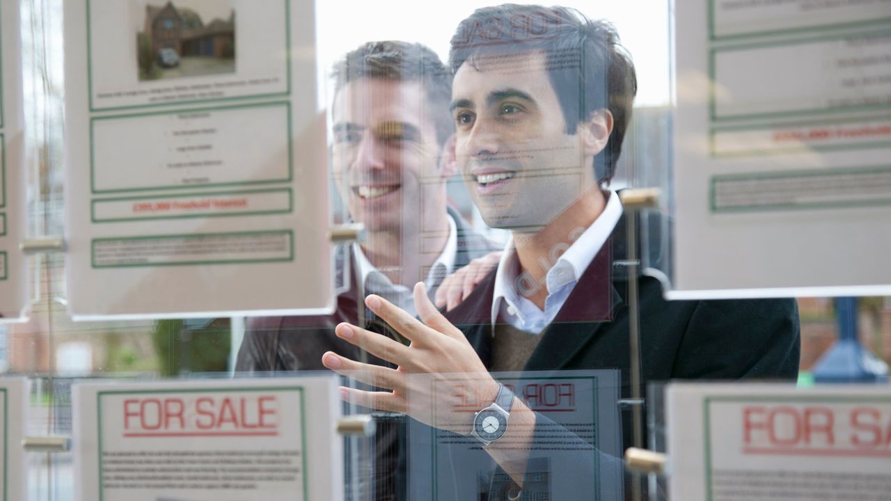 people looking in estate agent window