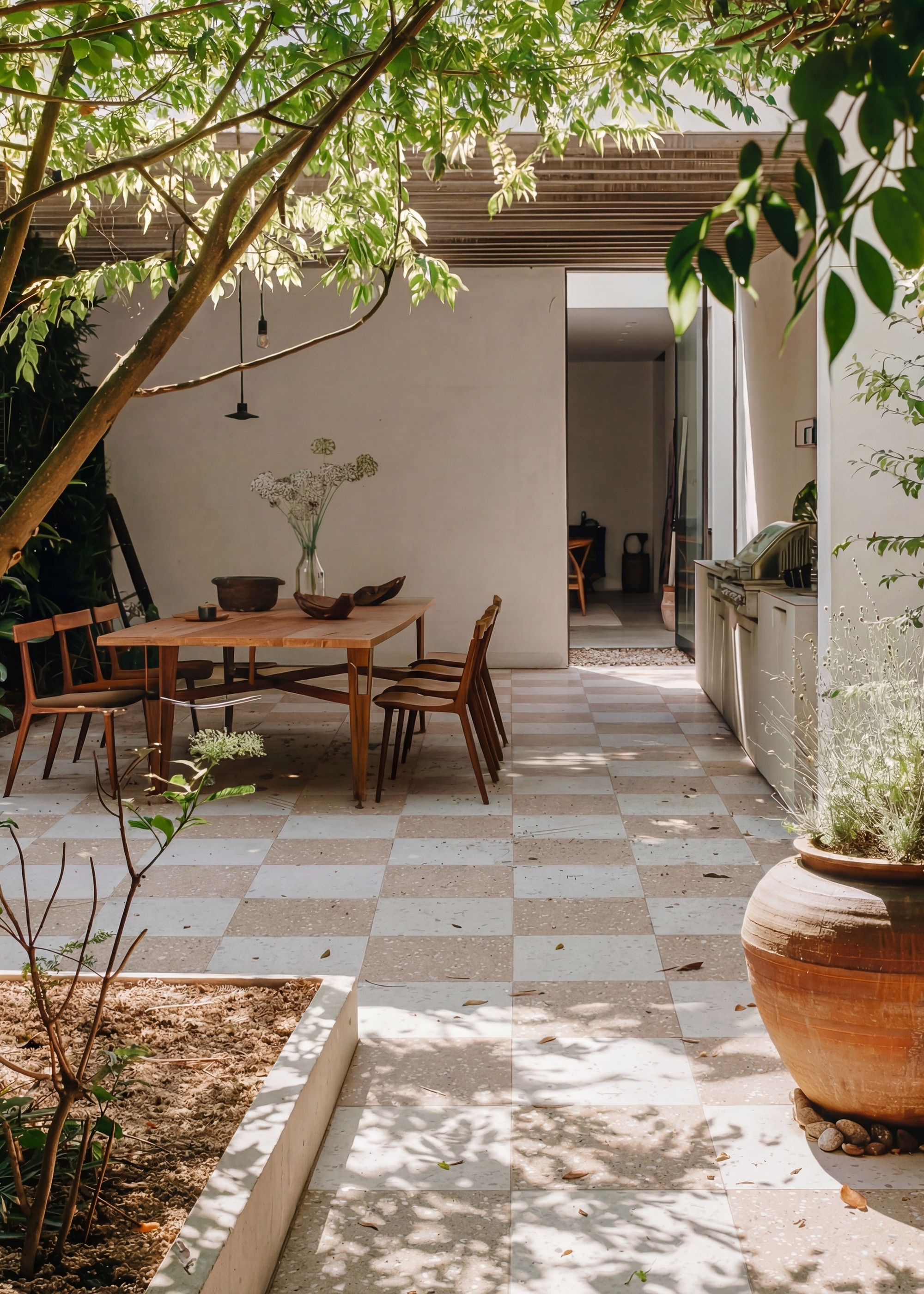 patio partly under cover with large dining table and chairs and ple pink checkerboard tiles