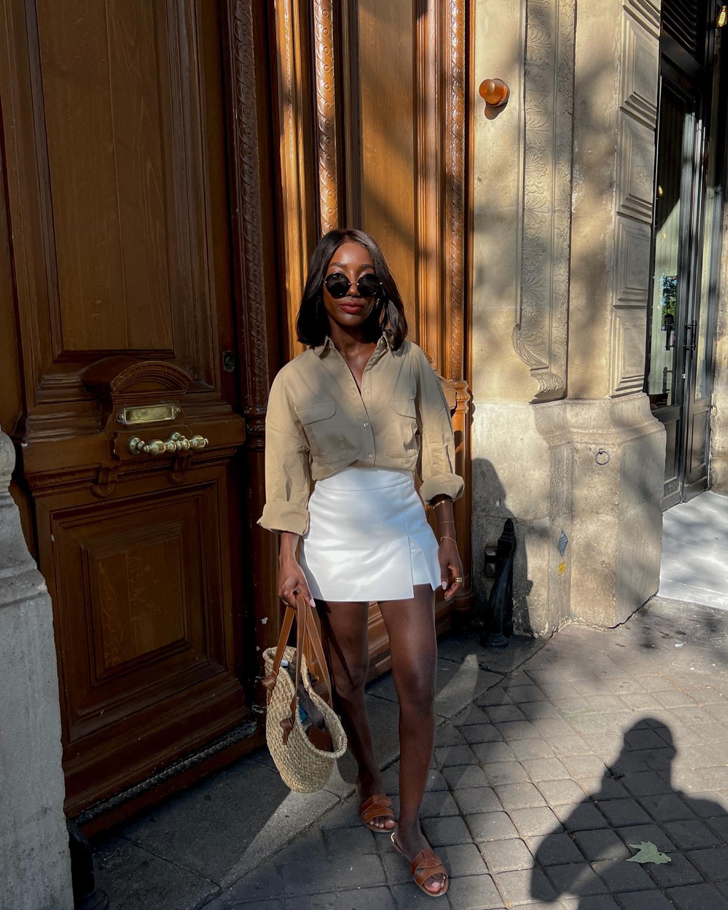 Aida Badji posing in white skirt and tan top