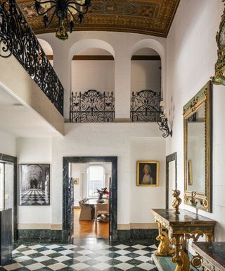 entrance ornate brass ceiling and iron balustrade black and white floor