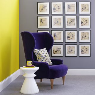 armchair with cushion yellow and grey wall with cup of tea