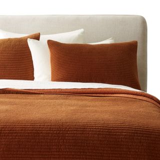 A velvet orange bedding set on a bed