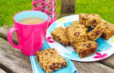 orange flapjacks with dates on a plate with a cup of tea