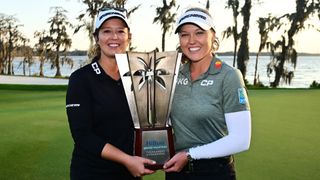 Brooke Henderson holding a trophy alongside her sister, Brittany, having won the 2023 Diamond Resorts Tournament of Champions
