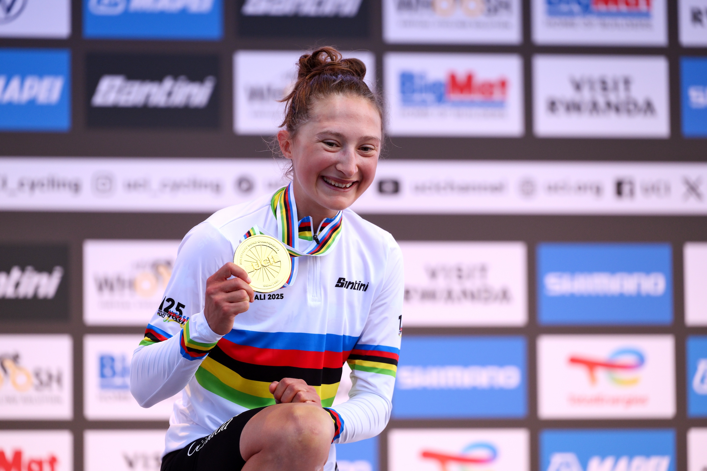 Magdeleine Vallieres stands on the World Championships 2025 podium wearing her rainbow jersey and showing off her winner&#039;s medal