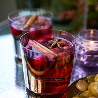 festive cocktail with cinnamon sticks, cranberries and star anais