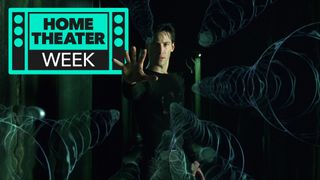 Morpheus from the Matrix holds his hand out to stop some bullets in mid-air. There is a logo for Home Theater Week in the corner