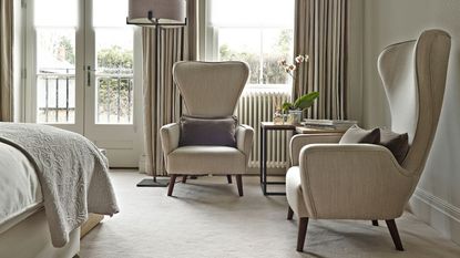 Carpeted master bedroom, armchairs