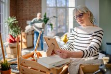 A cheerful senior couple is settling into their new home, unpacking boxes and enjoying the excitement of creating a cozy living space together
