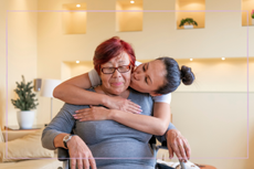 Woman with her arms around an older relative