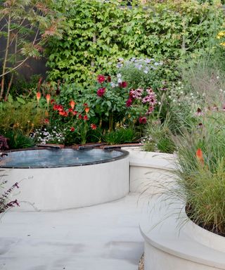 curved patio edged with low walls and modern water feature