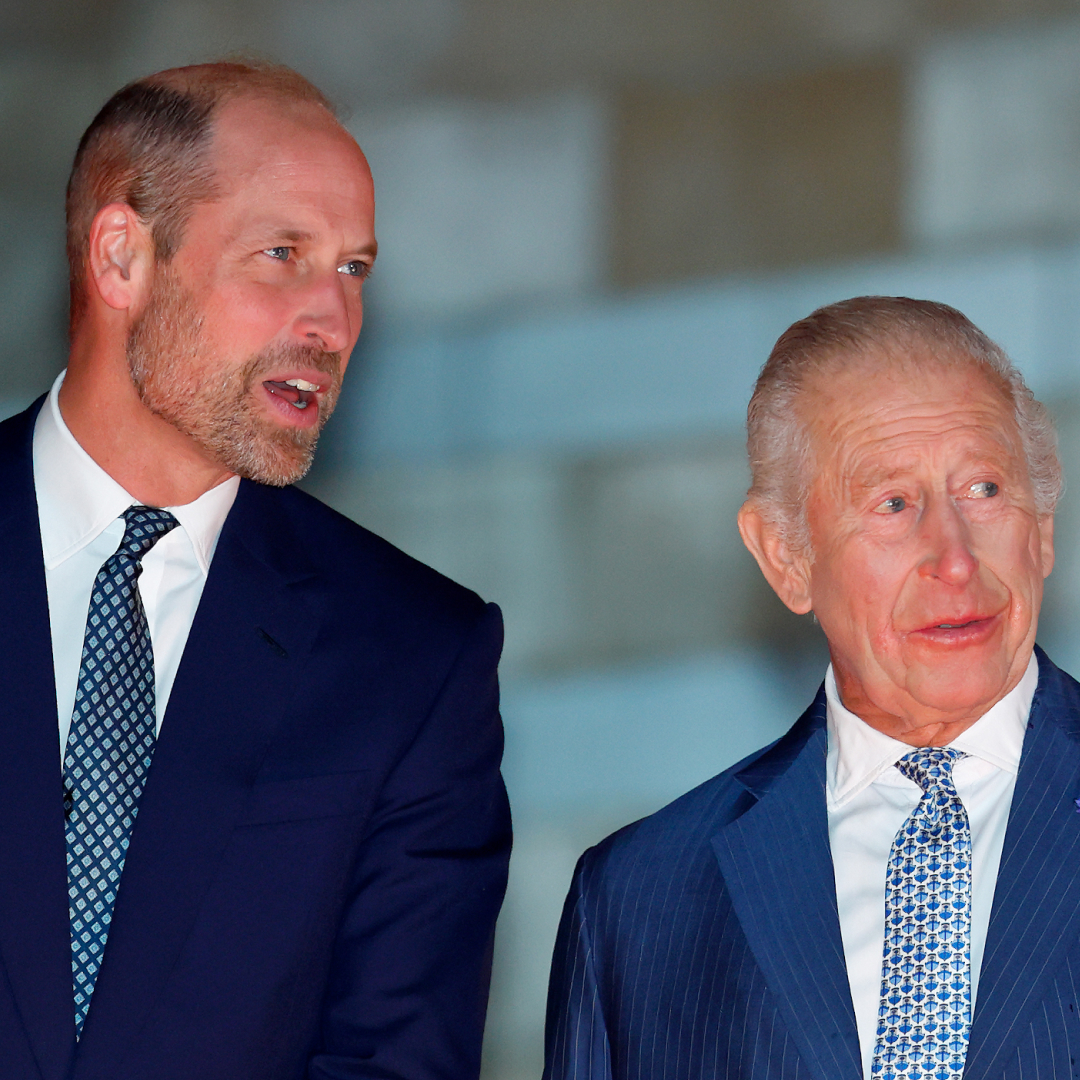 King Charles and Prince William talking to each other wearing blue suits