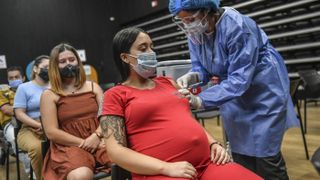A pregnant woman is inoculated with Pfizer’s COVID-19 vaccine in Medellin, Colombia, on July 24, 2021.