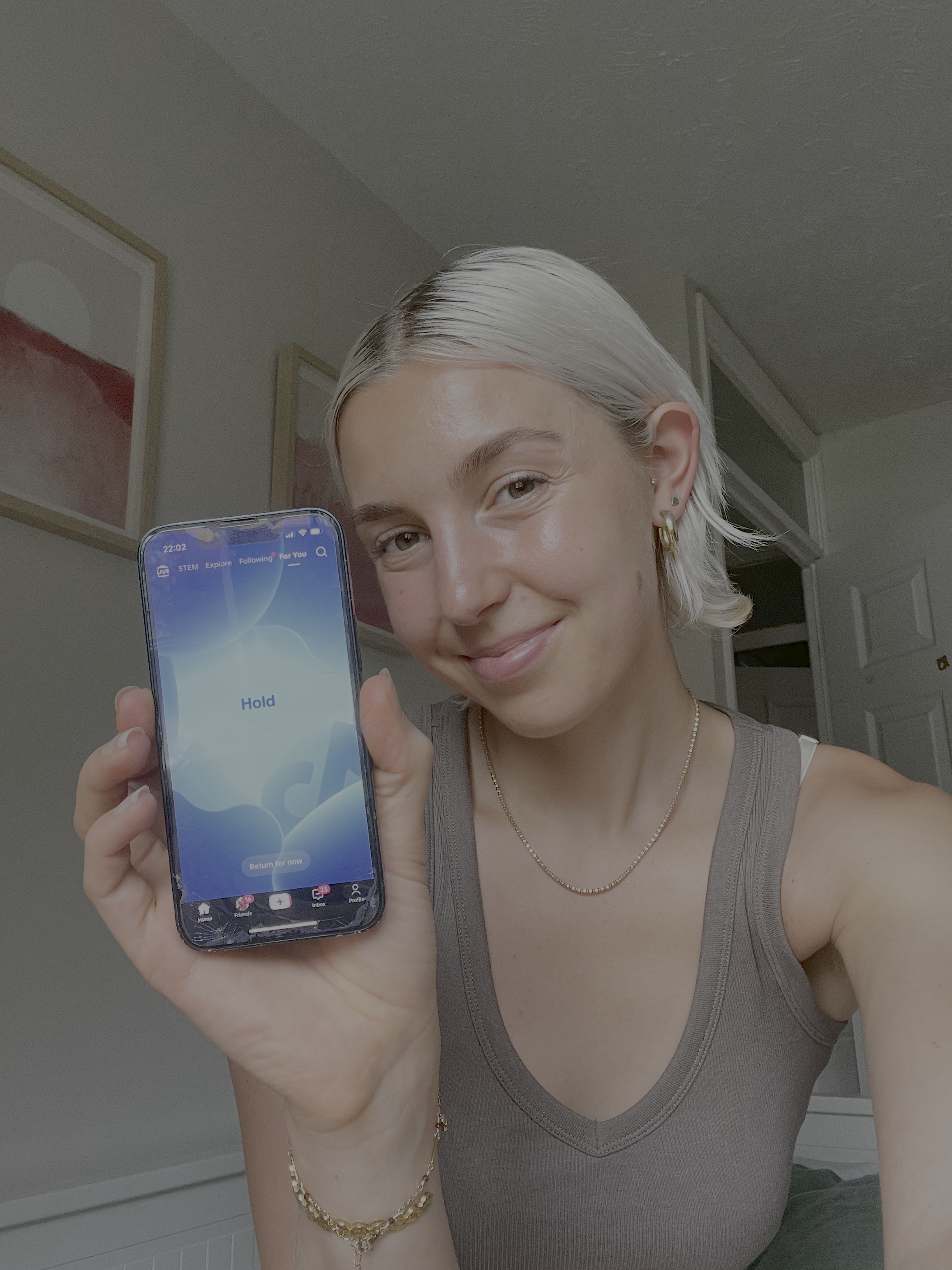 A woman holding her phone showing a blue screen with a guided breathwork exercise