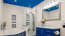 bathroom with blue painted ceiling and matching blue vanity and tiles