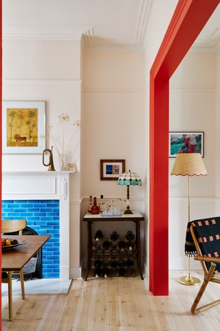 A living room with off-white walls and an arch architrave painted in bright red