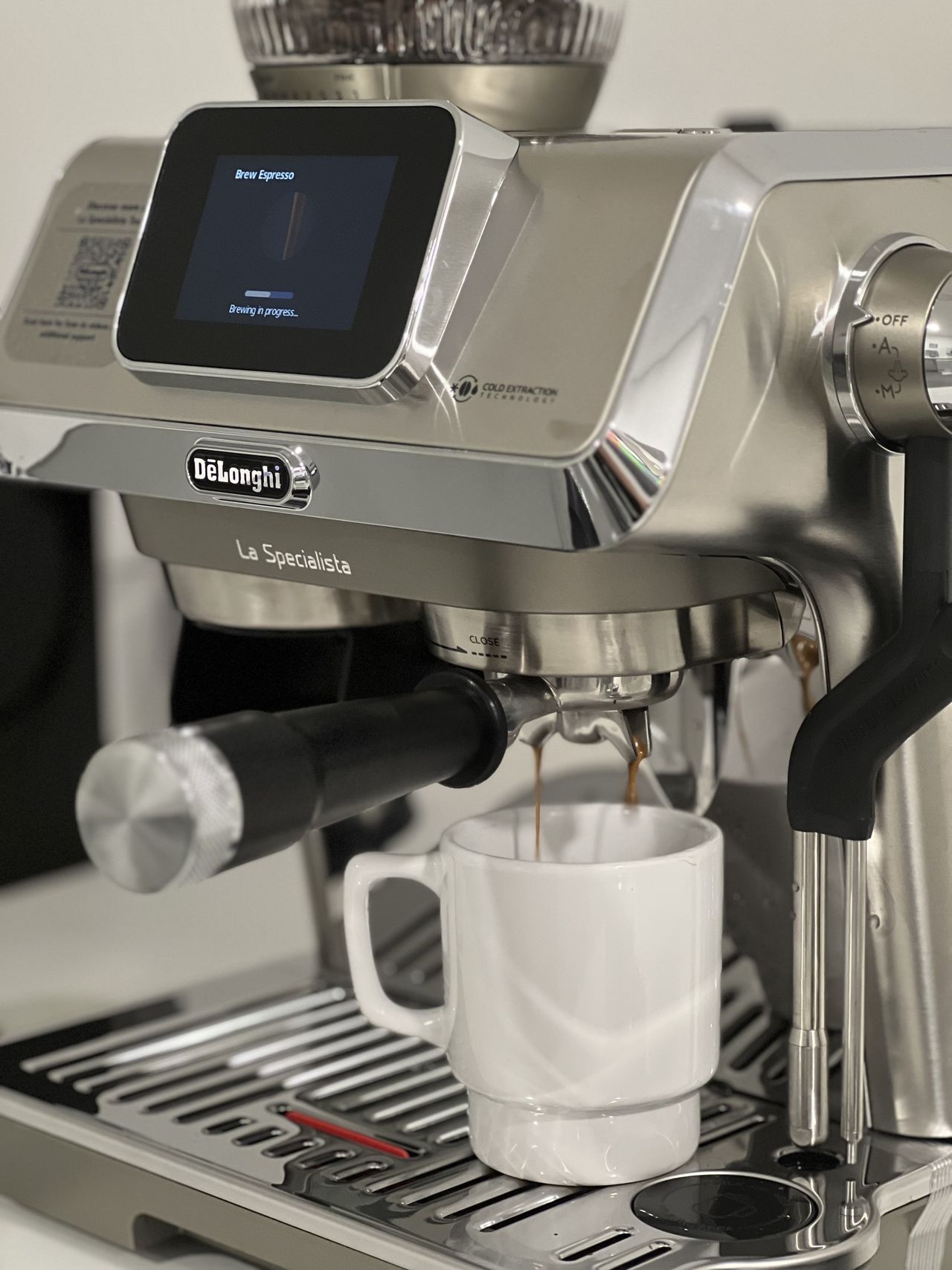 Close up image of the De'Longhi Specialista Touch brewing a shot of espresso into a white coffee mug.