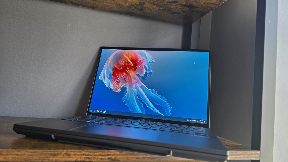 The Asus Zenbook Duo laptop photographed on a wooden desk.