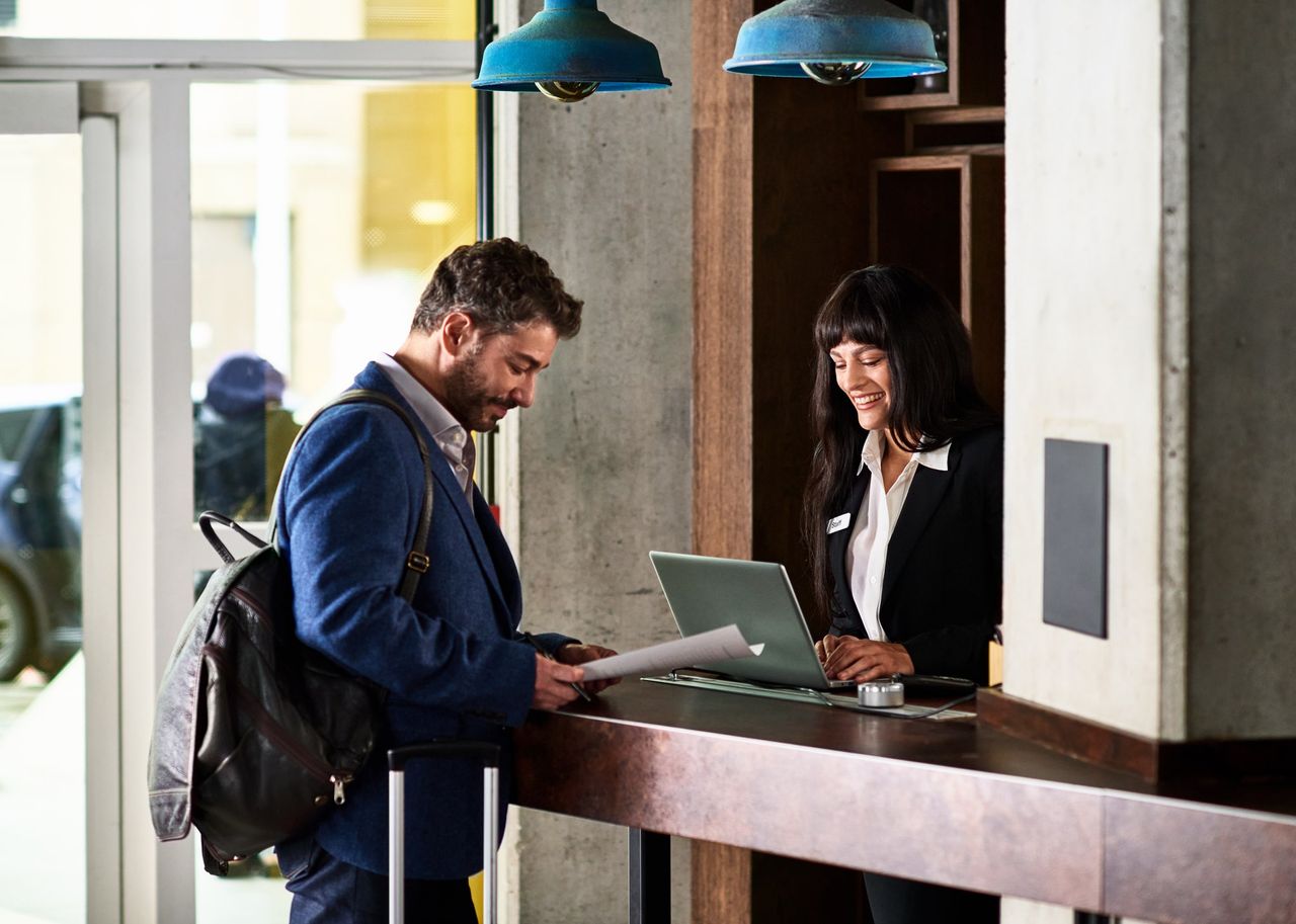 Man checking in at hotel reception