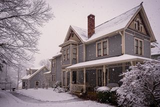 american house in winter with ice and snow