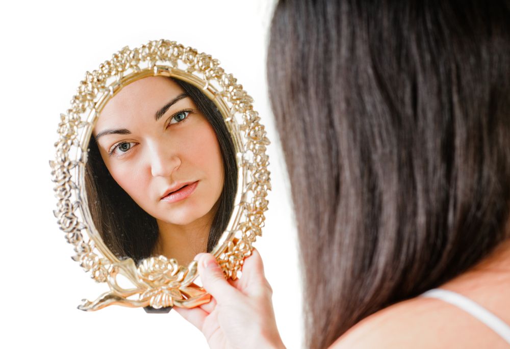 Woman looking in mirror, reflection