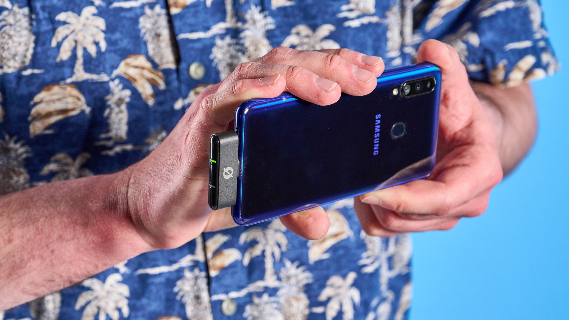 the rode wireless micro microphone with the black charging case and two black transmitter mics photographed against a blue background