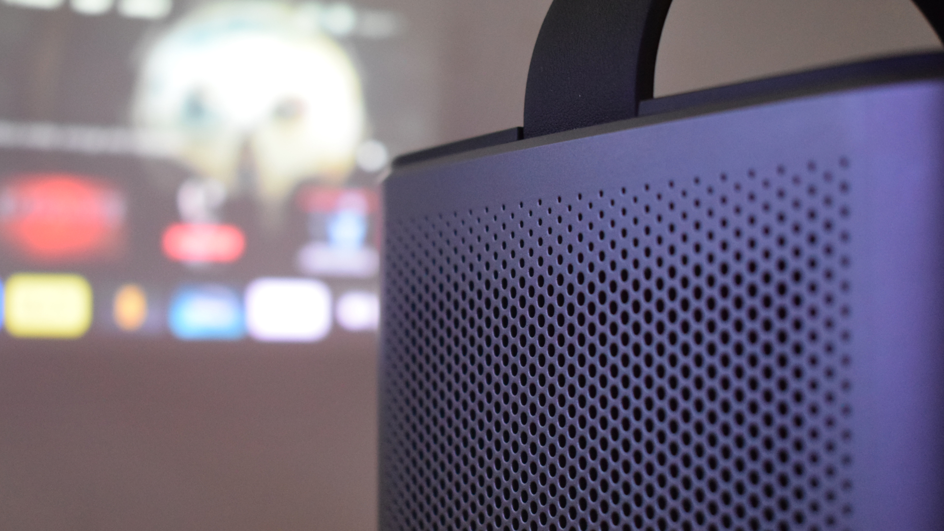 Anker Nebula Mars 3 Air projector side speaker grille close-up with projected image in background