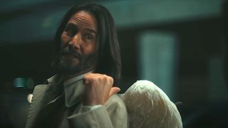 Keanu Reeves as Gabriel points to his angel wings in Good Fortune.