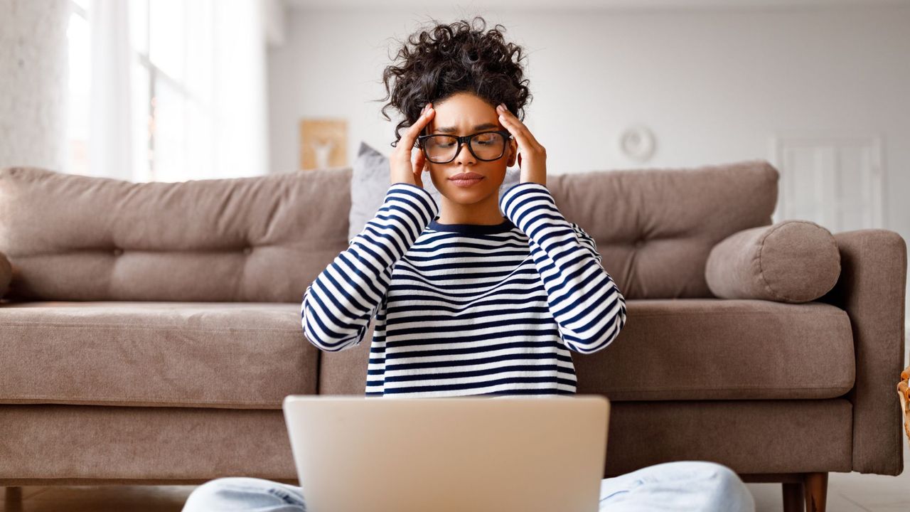 How to avoid burnout: A stressed woman holding her temples