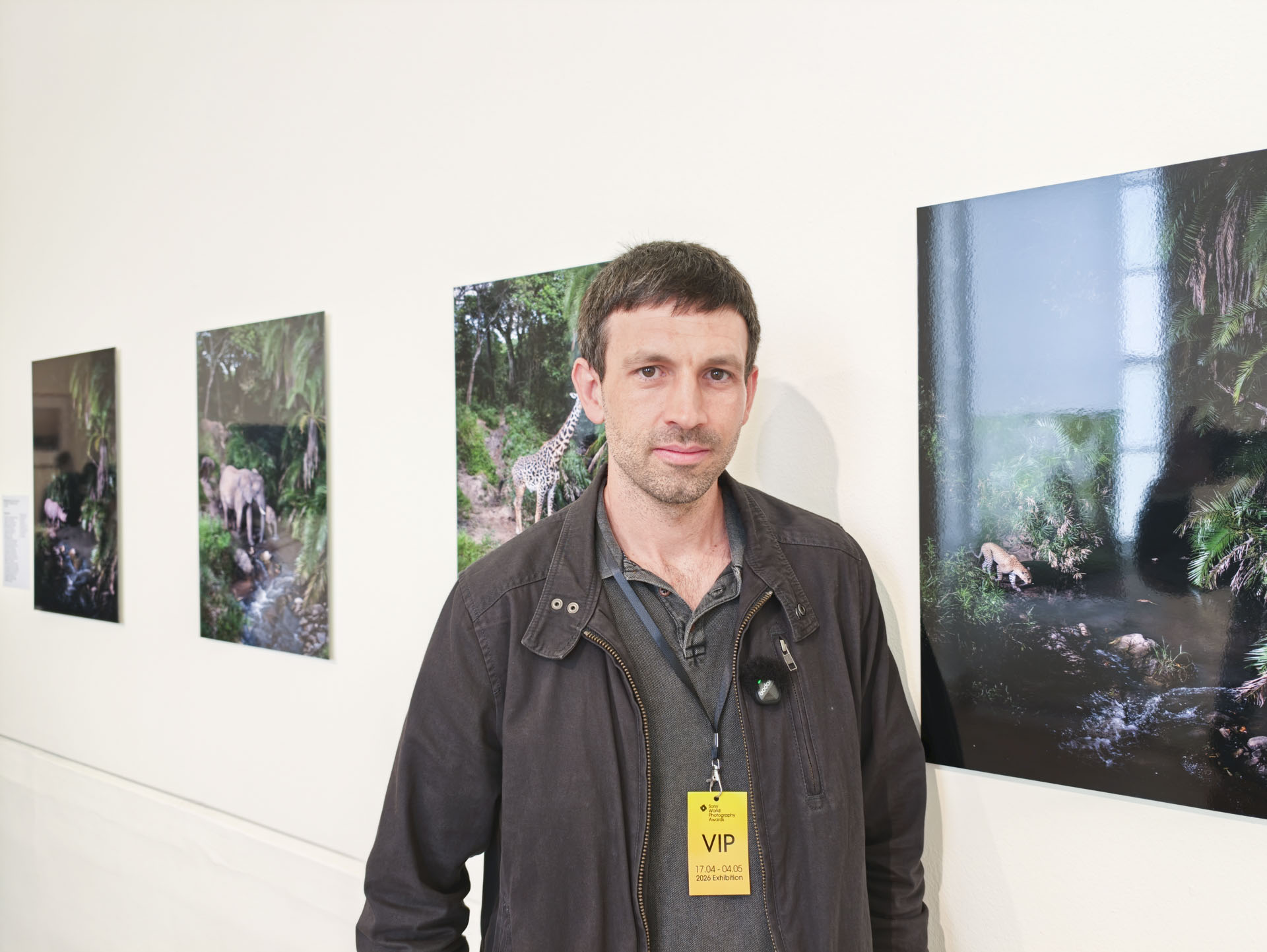 Wildlife photographer Will Burrard-Lucas standing by his SWPA 2026-winning images at the contest's exhibition in Somerset House, London