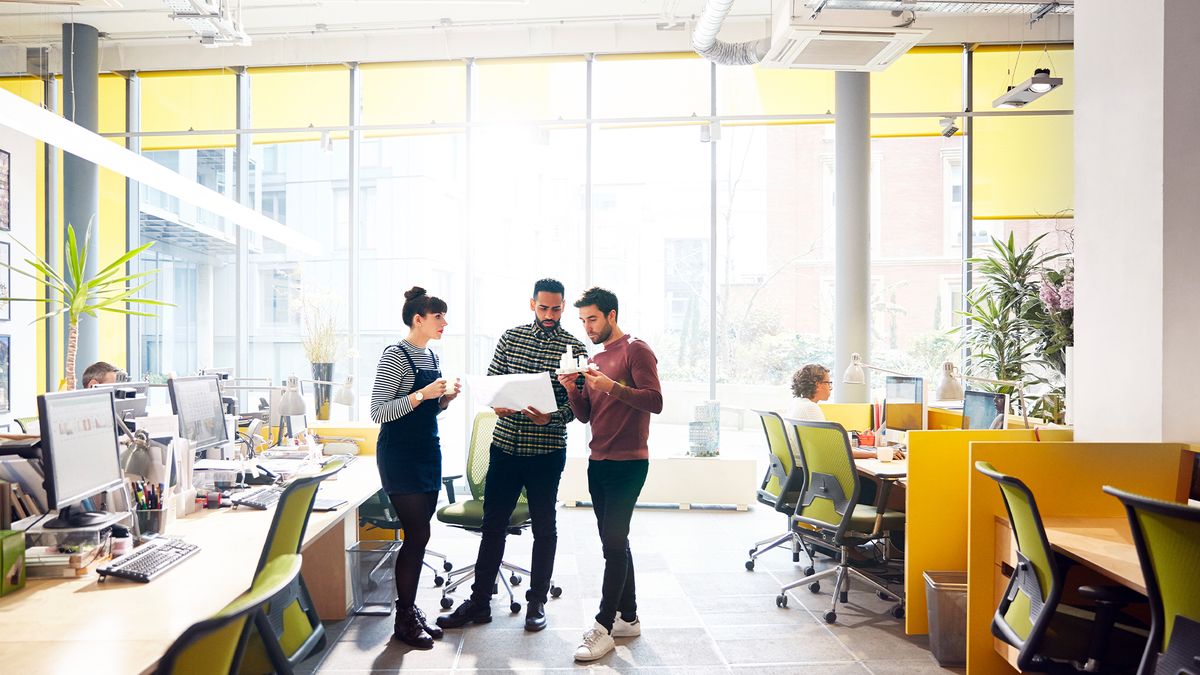 Data governance team members having an impromptu meeting in an open plan office space.