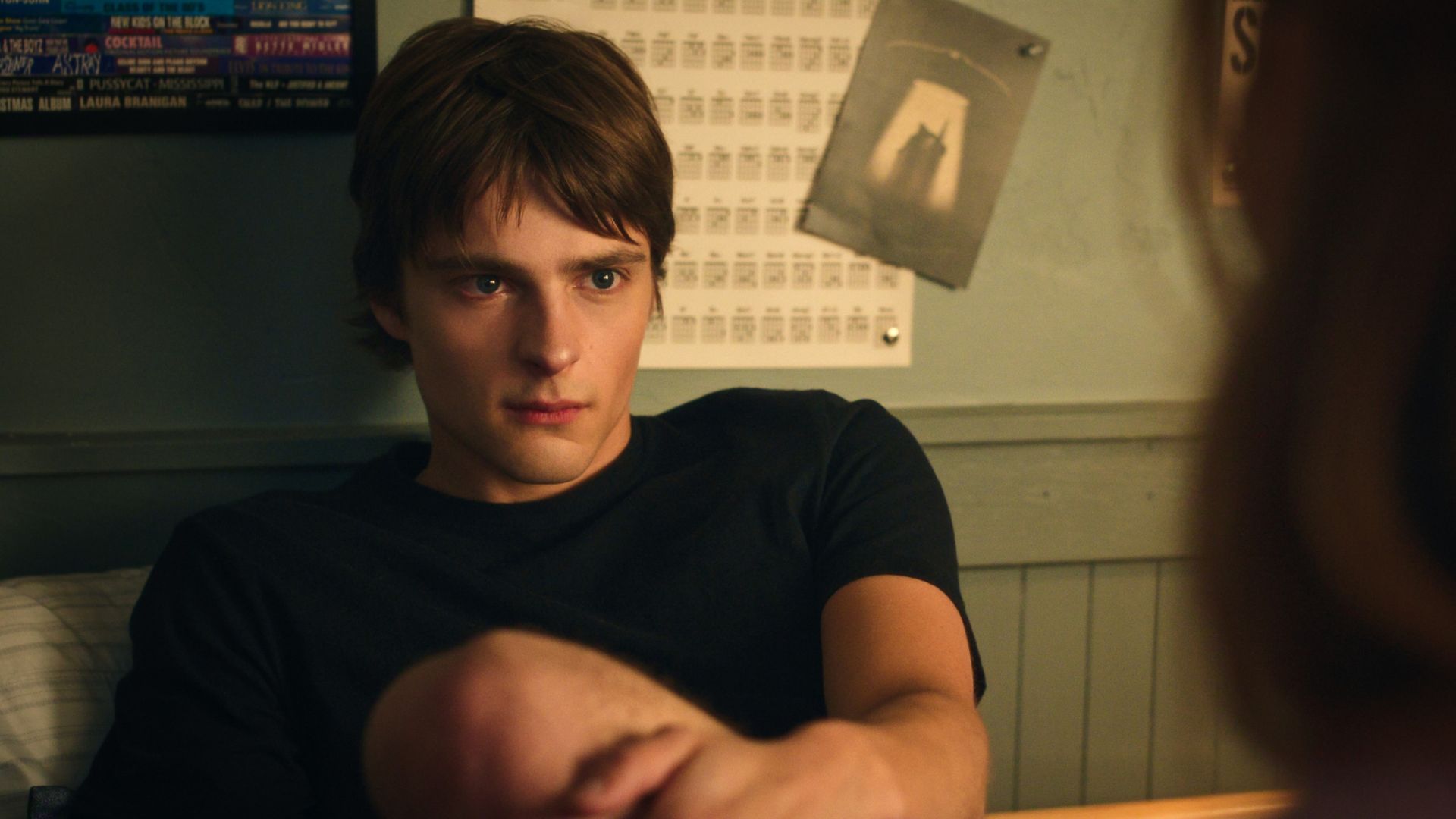 Nathan looks at someone from across his bed