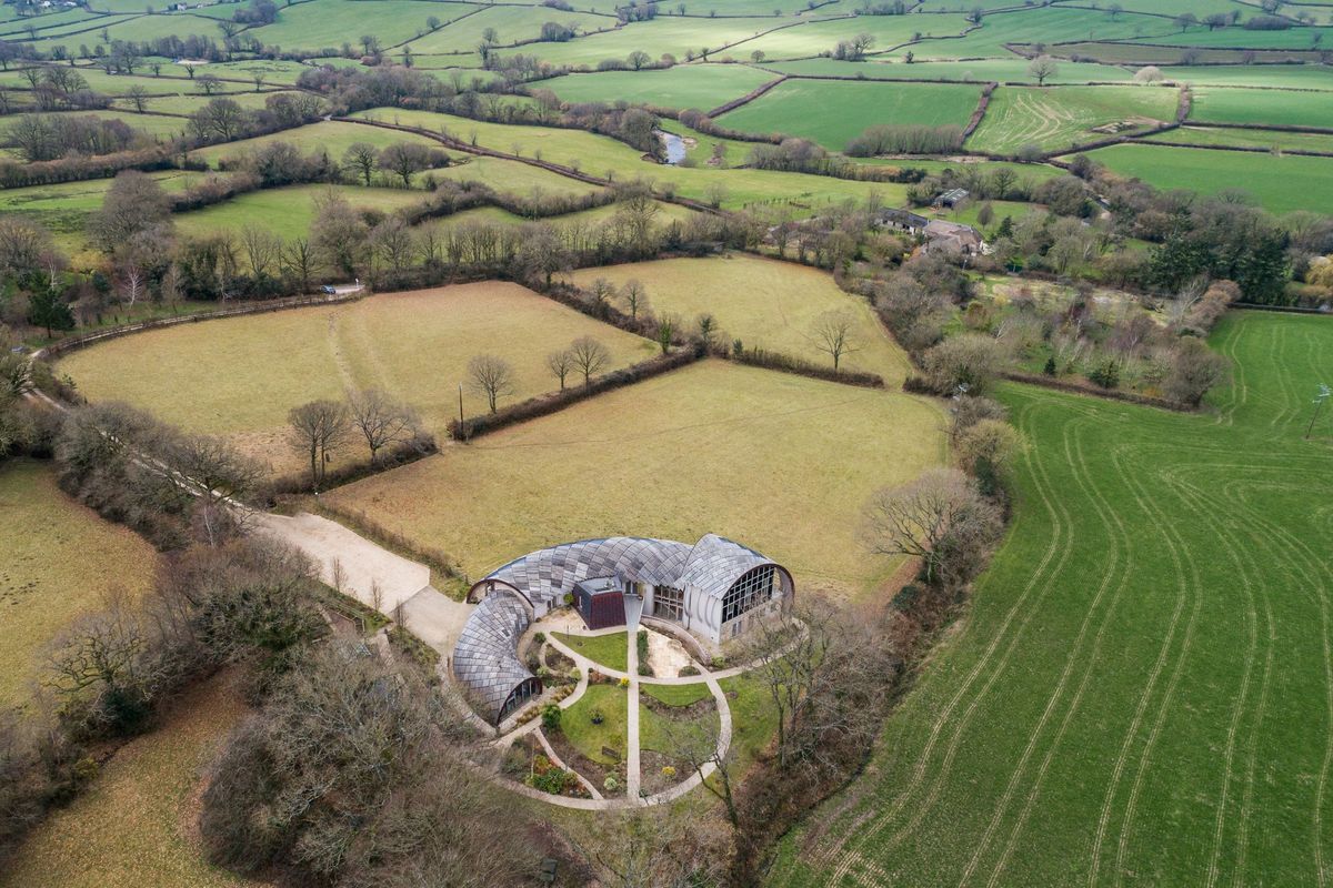 An overhead shot of the house showing the surrounding fields and its dome, curved structure