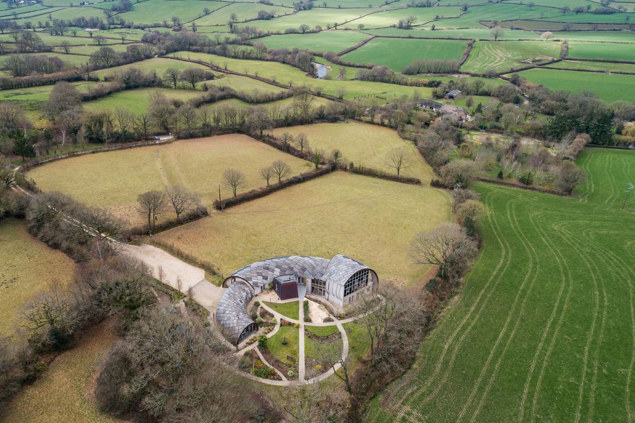 An overhead shot of the house showing the surrounding fields and its dome, curved structure