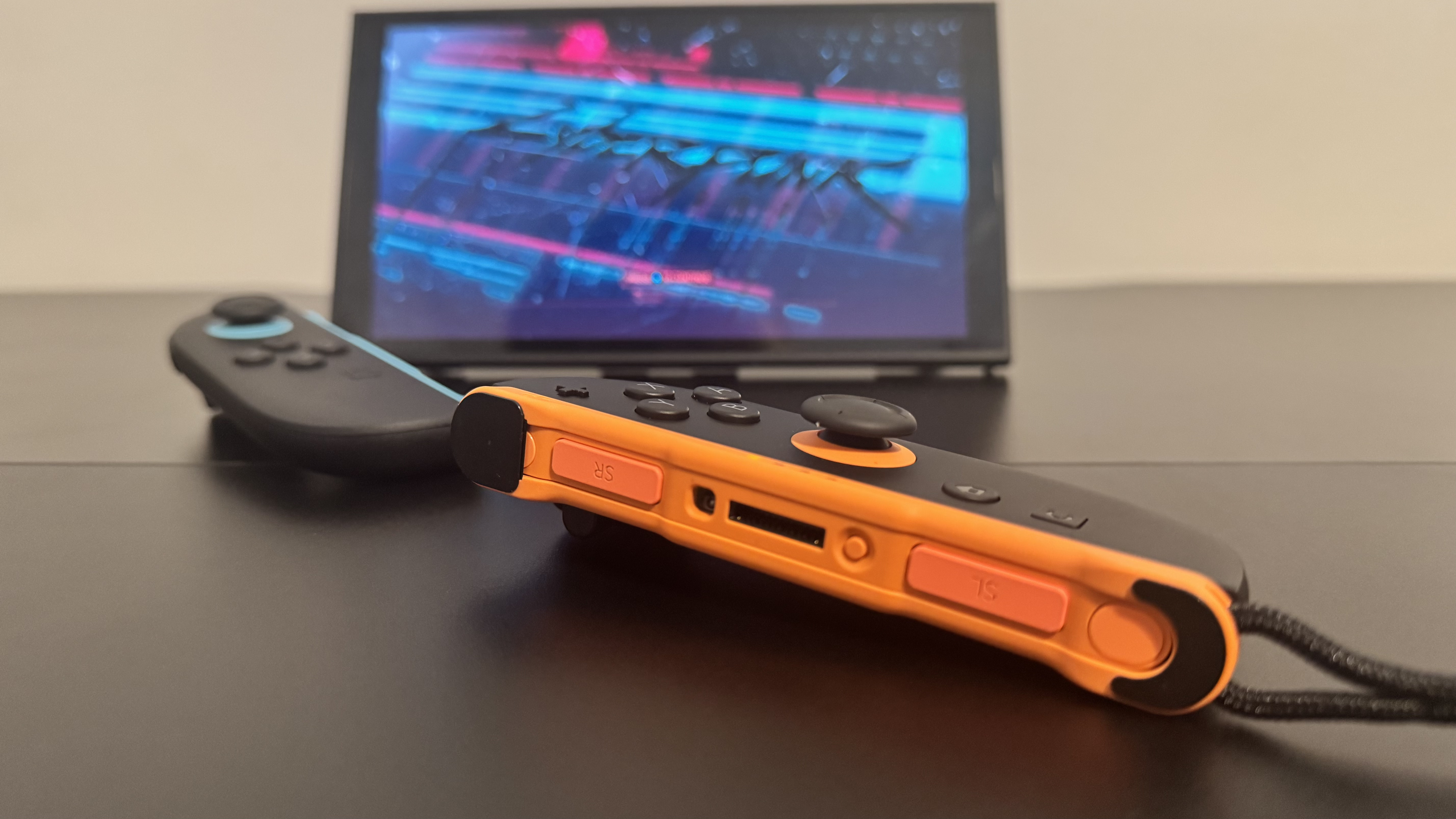 A picture of a Nintendo Switch 2, in mouse mode, with Cyberpunk 2077 in the background
