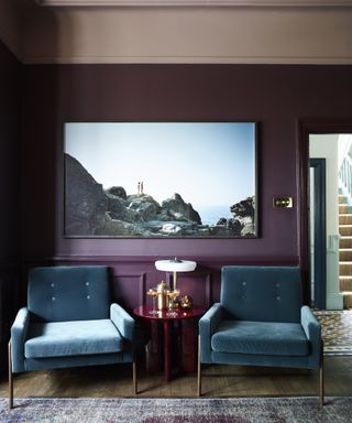 Purple living room with blue chairs and modern art