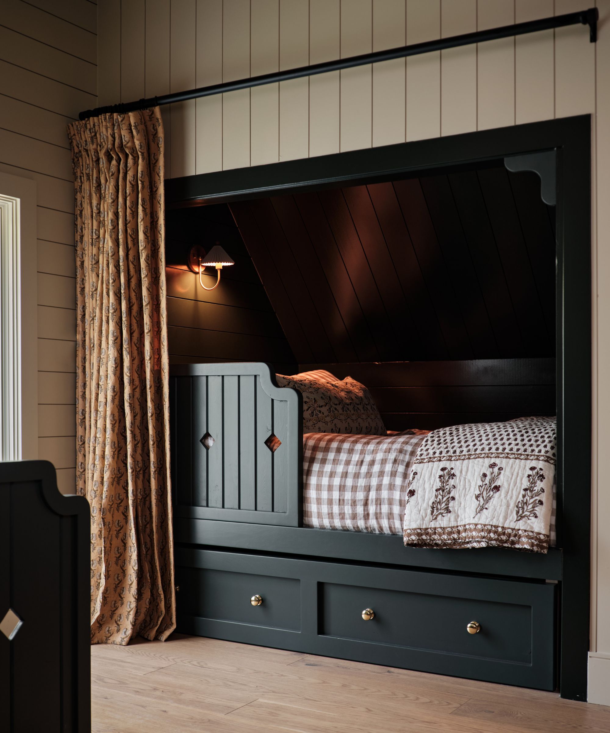 Bedroom with shiplap walls, built-in bed nook painted in dark blue, and gingham bedding and blockprint throw
