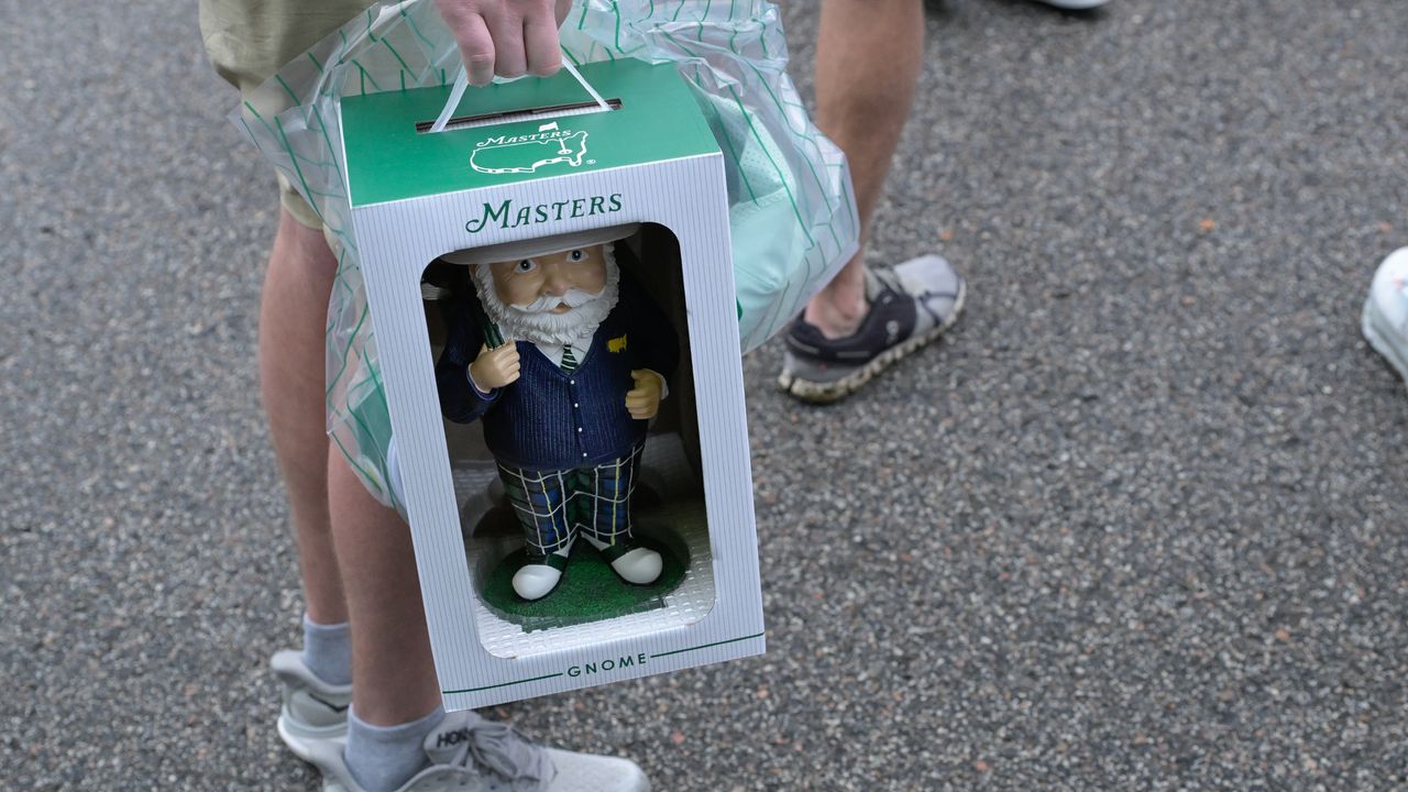 A patron carries a gnome at The Masters