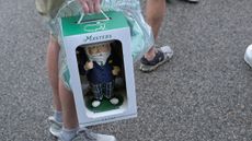 A patron carries a gnome at The Masters