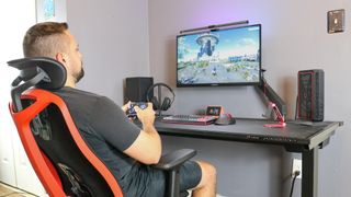 A person leaning back while gaming seated in the Herman Miller Vantum gaming chair