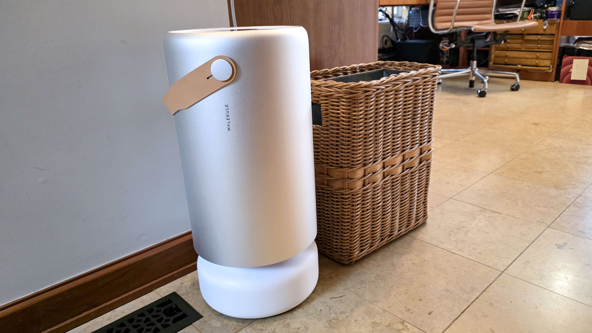 Molekule Air Pro purifier next to rattan basket on tiled floor