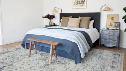 Blue rug in white bedroom with blue bedding